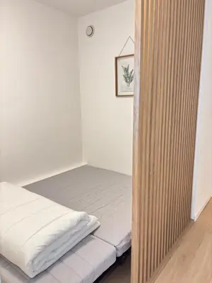 a bedroom with a bed and a wooden partition at Sea View Apartment 50 m to Beach FREE Parking in Cagnes-sur-Mer