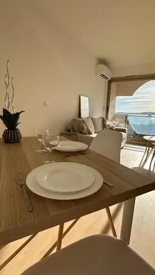 a table with a plate on it in a living room at Sea View Apartment 50 m to Beach FREE Parking in Cagnes-sur-Mer