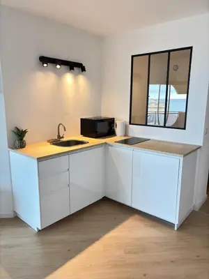 a white kitchen with a sink and a mirror at Sea View Apartment 50 m to Beach FREE Parking in Cagnes-sur-Mer