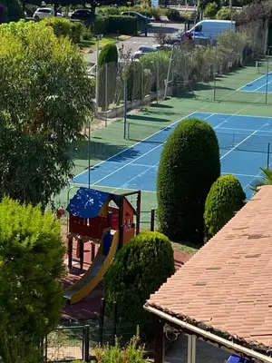 a view of a tennis court with a playground at Appartement Résidence Héliotel in Saint-Laurent-du-Var