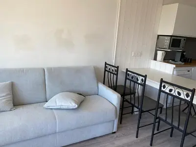 a living room with a couch and a kitchen at Appartement Résidence Héliotel in Saint-Laurent-du-Var