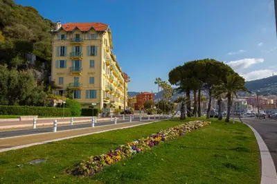 a street in a city with a building and flowers at Cocon D'Azur - 5min from the beach - Happy Rentals in Nice
