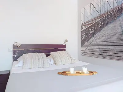 a bed with two pillows and a picture of a staircase at Apartment Le Mascoïnat by Interhome in Nice