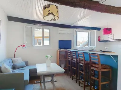 a living room with a blue couch and a kitchen at Apartment Le Mascoïnat by Interhome in Nice