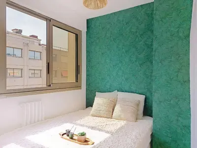 a bedroom with a bed with a green wall at Apartment Le Nice Etoile by Interhome in Nice