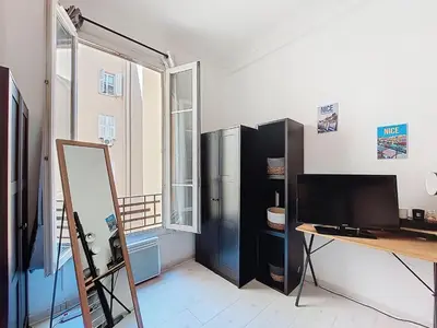 a room with a black refrigerator and a desk at Apartment Le Gambetta by Interhome in Nice