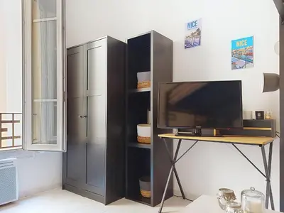 a room with a desk and a tv and a shelf at Apartment Le Gambetta by Interhome in Nice