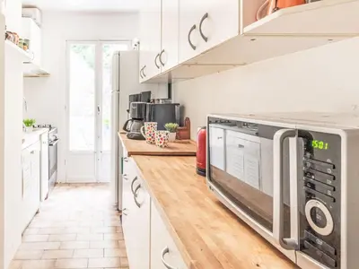 a kitchen with white cabinets and a microwave at Apartment L'Helios by Interhome in Nice