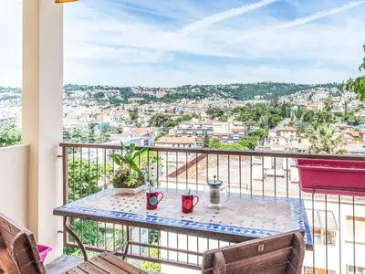 a table on a balcony with a view of a city at Apartment L'Helios by Interhome in Nice