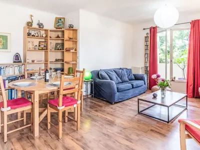 a living room with a table and a blue couch at Apartment L'Helios by Interhome in Nice