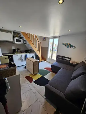 a living room with a couch and a kitchen at Appartement 2 pièces à 5 mn de la plage N3 in Saint-Laurent-du-Var