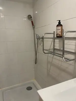 a shower in a white tiled bathroom with a sink at Appartement 2 pièces à 5 mn de la plage N3 in Saint-Laurent-du-Var