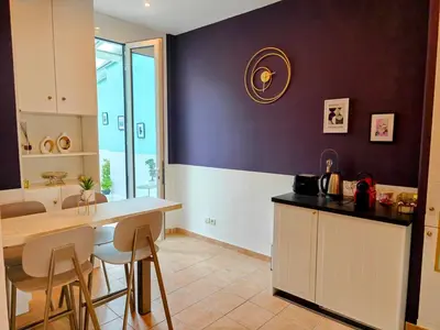 a kitchen with a counter and a table and chairs at Spacious NEW Apt near Promenade up to 6 with AC in Nice
