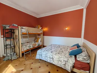 a bedroom with two bunk beds and orange walls at Spacious NEW Apt near Promenade up to 6 with AC in Nice