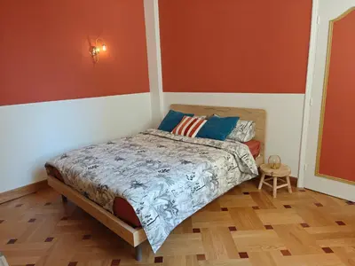 a bedroom with a bed with orange and white walls at Spacious NEW Apt near Promenade up to 6 with AC in Nice