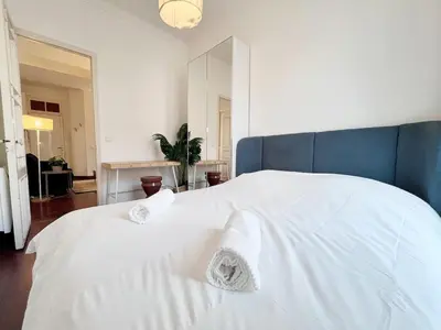 a bedroom with a large white bed with a blue headboard at RF109 - Spacieux 4P au cœur de Nice in Nice