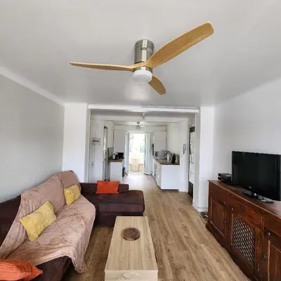 a living room with a couch and a ceiling fan at Charmant appartement au calme à proximité du Port, de la vieille ville de Nice , de la Promenade des Anglais in Nice