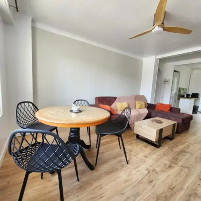 a living room with a table and chairs and a couch at Charmant appartement au calme à proximité du Port, de la vieille ville de Nice , de la Promenade des Anglais in Nice