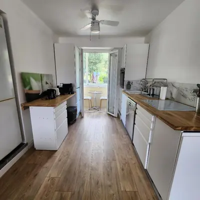 a kitchen with white cabinets and a ceiling fan at Charmant appartement au calme à proximité du Port, de la vieille ville de Nice , de la Promenade des Anglais in Nice
