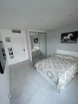 a bedroom with a bed and a mirror at Sea view apartment in Cagnes-sur-Mer