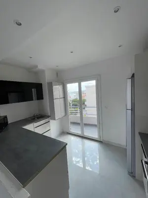 a kitchen with white walls and a large window at Sea view apartment in Cagnes-sur-Mer
