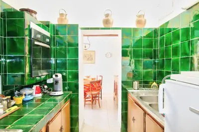 a green tiled kitchen with a sink and a table at Villa La Rara Beaulieu Centre in Beaulieu-sur-Mer