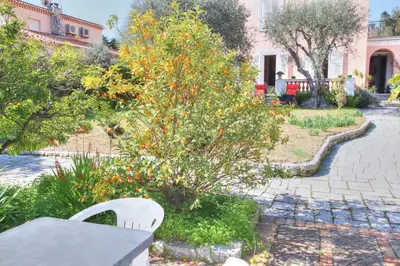 a bench in a garden with an orange tree at Villa La Rara Beaulieu Centre in Beaulieu-sur-Mer