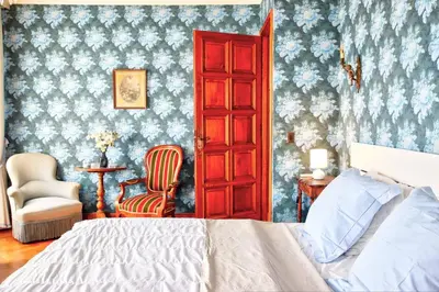 a bedroom with a bed and a red door at Villa La Rara Beaulieu Centre in Beaulieu-sur-Mer