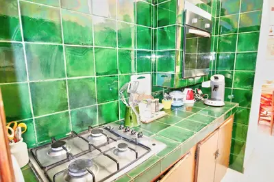 a green tiled kitchen with a stove top oven at Villa La Rara Beaulieu Centre in Beaulieu-sur-Mer