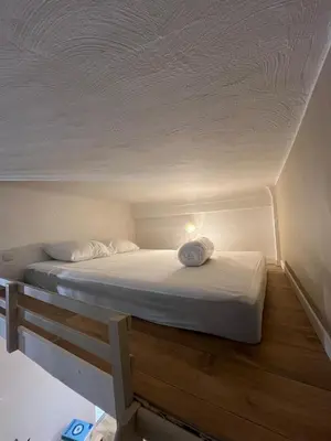 a bed in a room with a white ceiling at Studio confort proche du port in Nice