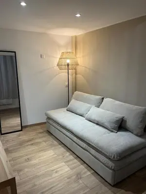 a couch sitting in a room with a lamp at Studio confort proche du port in Nice