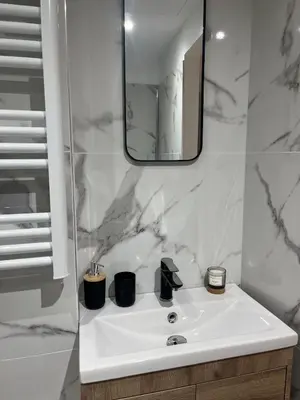 a white bathroom with a sink and a mirror at Studio confort proche du port in Nice
