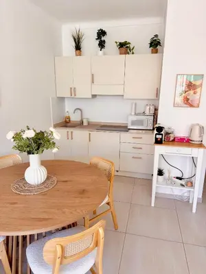 a kitchen with a wooden table and a table and chairs at Chic & cosy proche mer in Nice