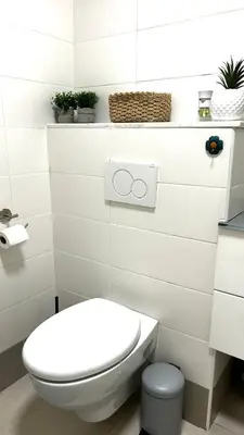 a white bathroom with a toilet and some plants at Chic & cosy proche mer in Nice
