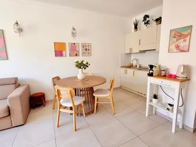 a living room and kitchen with a table and a couch at Chic & cosy proche mer in Nice