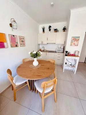 a kitchen and dining room with a wooden table and chairs at Chic & cosy proche mer in Nice