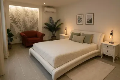 a bedroom with a large white bed and a chair at Charmant appartement 3 grandes chambres au coeur de Nice au calme absolu in Nice