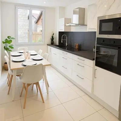 a white kitchen with a table and chairs in it at Charmant appartement 3 grandes chambres au coeur de Nice au calme absolu in Nice