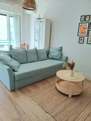 a living room with a blue couch and a table at Charmant T2 proche tramway et plages in Nice