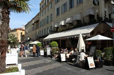 a group of people sitting at tables outside a building at Appart Le Carré D'Or in Nice