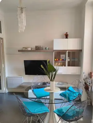 a living room with a table and chairs and a tv at Appart Le Carré D'Or in Nice