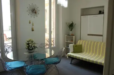 a living room with a glass table and a couch at Appart Le Carré D'Or in Nice