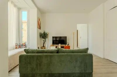 a living room with a green couch and a television at Nice Magnan, Appartement proches plage et tramway in Nice