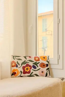 a pillow sitting on top of a bed with a window at Nice Magnan, Appartement proches plage et tramway in Nice