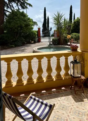 a yellow balcony with a chair and a pool at Elegant apartment, Cap de Nice in Nice