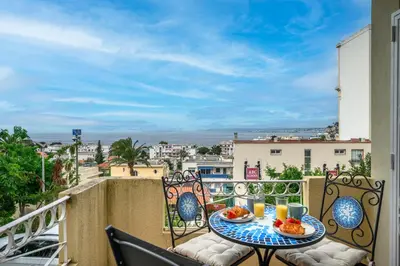 a balcony with a table with food and drinks on it at Villa Nissarda, Maison Niçoise avec vue mer, parking, à 5 minutes du port in Nice