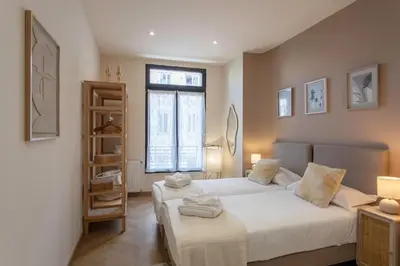 a bedroom with two beds and a book shelf at #52 Etoile Suite ,Central, Balcony, AC-5 min P Massena in Nice