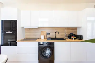 a kitchen with white cabinets and a washing machine at #52 Etoile Suite ,Central, Balcony, AC-5 min P Massena in Nice