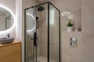 a bathroom with a glass shower and a sink at #52 Etoile Suite ,Central, Balcony, AC-5 min P Massena in Nice