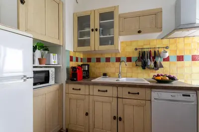 a kitchen with wooden cabinets and a white refrigerator at VUE ROSSETTI AP4465 by Riviera Holiday Homes in Nice